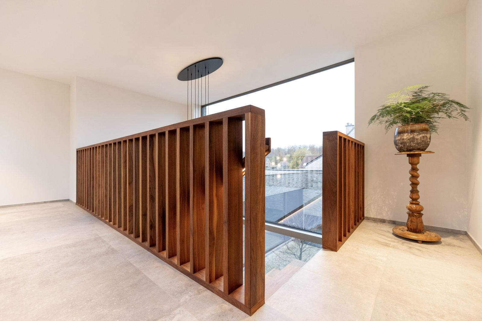 Houten lattenbalustrade op een lichte overloop met groot raam