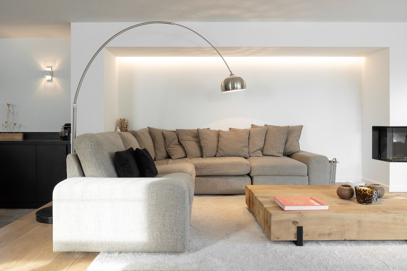 Woonkamer met een lichte eiken plankenvloer en een grote zetel