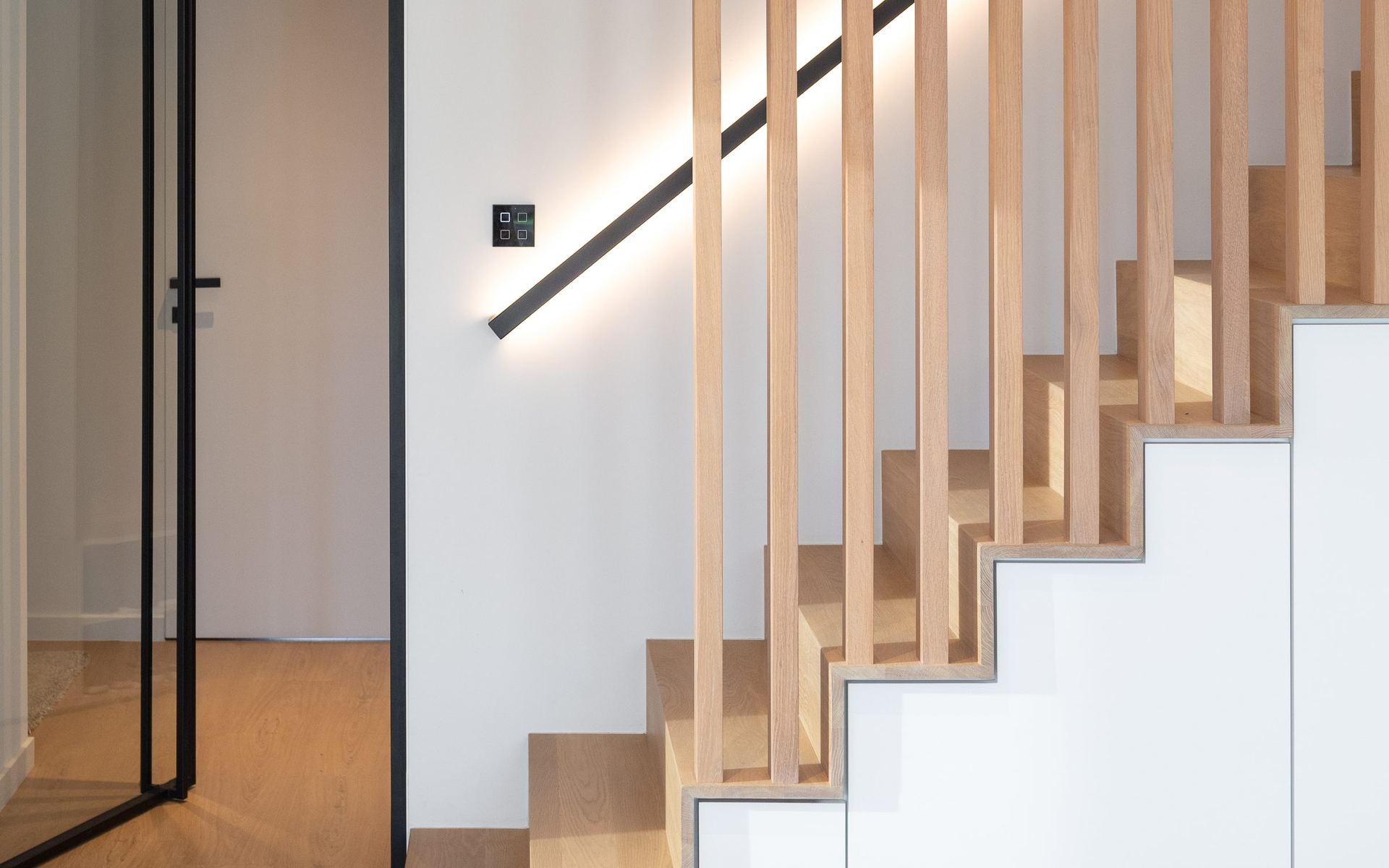 Houten trap achter latten met geïntegreerde ledleuning